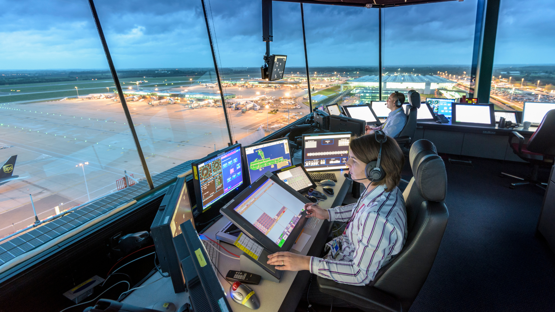Air traffic controllers at work looking over airport gates and runways